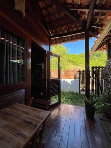 a wooden porch with a wooden table and a fence at Chalés Paradise in Atins