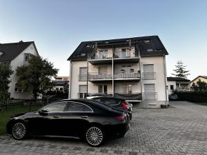 a black car parked in front of a building at STAY - Comfort Apartment in Friedrichshafen