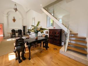 a living room with a table and a staircase at A Capela - A Essência de Sintra in Sintra