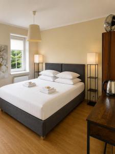 a bedroom with a large bed with white sheets and pillows at Villa Jeziorki in Warsaw