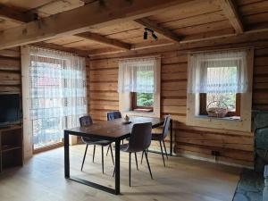 a dining room with a table and chairs and windows at Śleboda Home&Spa in Gliczarów Górny