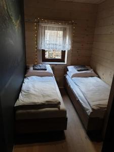 three beds in a small room with a window at Śleboda Home&Spa in Gliczarów Górny