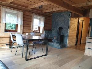 a dining room with a table and a fireplace at Śleboda Home&Spa in Gliczarów Górny