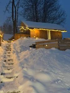a snow covered yard with a building with lights at Śleboda Home&Spa in Gliczarów Górny +6 photos