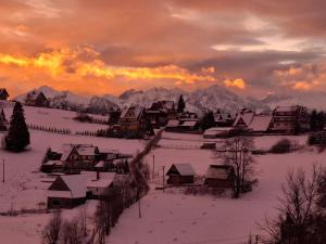 a village covered in snow with mountains in the background at Śleboda Home&Spa in Gliczarów Górny