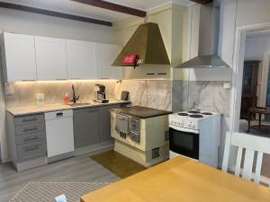 a kitchen with a stove top oven next to a table at Villa Tapiola in Lohja +11 photos