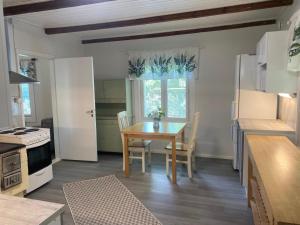 a kitchen with a wooden table and a table and a dining room at Villa Tapiola in Lohja