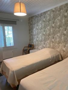 a bedroom with two beds and a wall at Villa Tapiola in Lohja