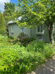 a green house with flowers in front of it at Villa Tapiola in Lohja