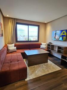 a living room with a couch and a large window at Ocean Rooftop Hotel in Ben Slimane