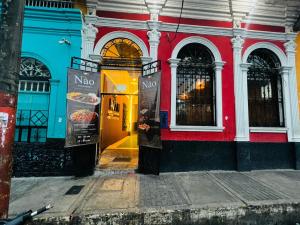 a red and white building with a no sign on it at Nau Guest House & Restaurant in Iquitos