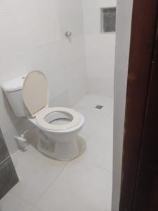 a bathroom with a toilet in a white room at Habitaciones centro Coquerita in Coveñas