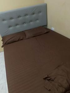 a bed with a blue headboard and brown sheets at Habitaciones centro Coquerita in Coveñas
