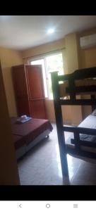 a bedroom with a bed and a window and a chair at Habitaciones centro Coquerita in Coveñas