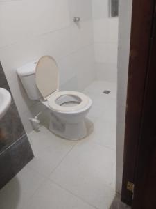 a white bathroom with a toilet and a sink at Habitaciones centro Coquerita in Coveñas