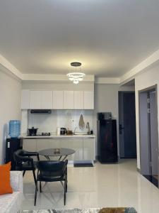 a living room with a table and a kitchen at Cozy Nest in Marimbeti