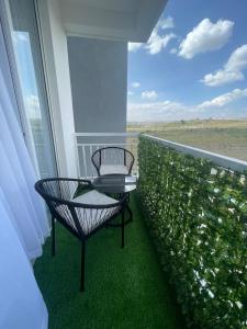 a balcony with two chairs and a table at Cozy Nest in Marimbeti