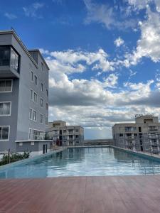 a large swimming pool in front of a building at Cozy Nest in Marimbeti
