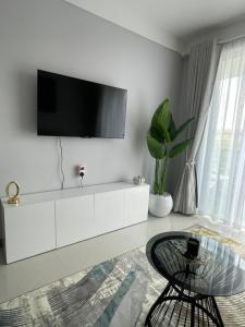 a living room with a white dresser with a tv on it at Cozy Nest in Marimbeti