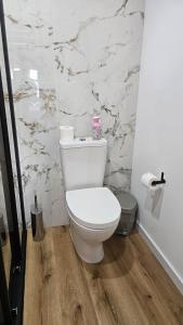 a white toilet in a bathroom with a marble wall at Fernandes Guest House Green Bungalow in Ponte de Lima +23 photos