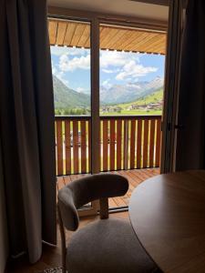 a room with a table and a view of a balcony at Almrösle Apartments in Lech am Arlberg