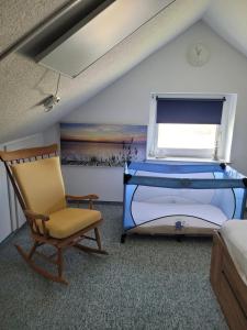 a bedroom with a bed and a chair and a window at Ferienhaus Frieda in Friedrichskoog
