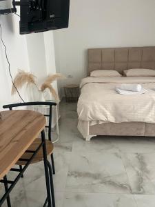a bedroom with a bed and a wooden table and a table at Studio Apartment Vukcevic 3 in Golubovci