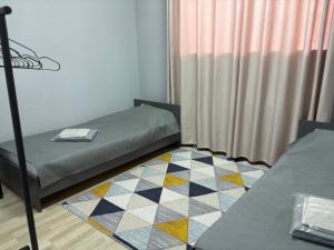 a small room with a bed and a rug at Astana Rooms in Astana