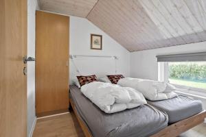 a bed with pillows on it in a room with a window at FY131-Middelfart-Stjernevej-111 in Middelfart +13 photos