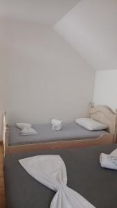 two beds in a room with white walls at Vukota - Kuca za odmor in Plav