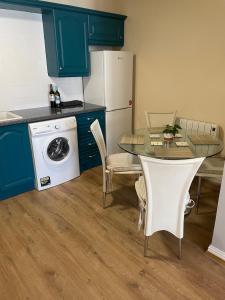 a kitchen with a table and chairs and a refrigerator at Modern Town Centre 3 Bed Apartment in Sligo