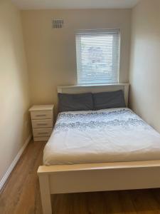 a small bedroom with a bed and a window at Modern Town Centre 3 Bed Apartment in Sligo