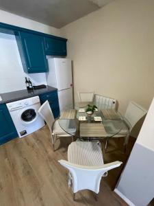 a small kitchen with a table and chairs and a refrigerator at Modern Town Centre 3 Bed Apartment in Sligo