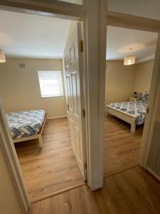 a room with two beds and a hallway at Modern Town Centre 3 Bed Apartment in Sligo +14 photos