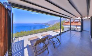 a balcony with a table and chairs and a view of the ocean at Villa Sky Line - Private Pool - Panoramic Sea View in Kaş