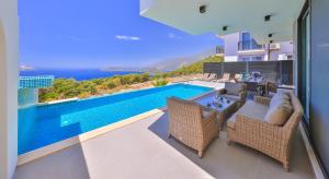 a house with a swimming pool and a view of the ocean at Villa Sky Line - Private Pool - Panoramic Sea View in Kaş