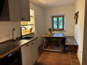 a kitchen with a wooden table and a sink at Stallrefugium - between lakes, mountains and silence in Seeon-Seebruck