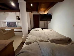 a room with two beds and a couch in it at Stallrefugium - between lakes, mountains and silence in Seeon-Seebruck