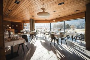 a restaurant with tables and chairs and a large window at Pension Longhin Maloja - Self Check In in Maloja