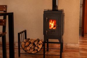 a wood burning stove with a bowl of logs at Olivos de Monte in San Miguel del Monte +115 photos