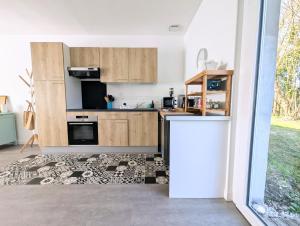 a kitchen with wooden cabinets and a rug at L'Échappée Verte - Maison familiale avec Jardin & Parking - 20 min du PuyduFou in Mauléon +22 photos