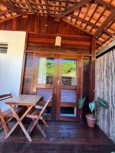 a porch of a house with a table and chairs at Chalés Paradise in Atins