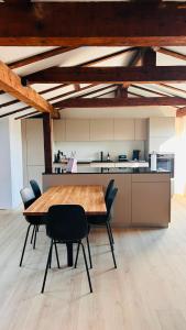 a kitchen with a wooden table and chairs in a room at 130sqm Duplex with AirC - Gratis Parking - Familie Freunde - See und Jura in Biel