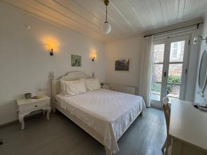 a white bedroom with a bed and a window at Gule Cunda in Ayvalık