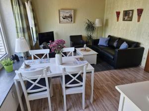 a living room with a table and chairs and a couch at Haus Schildt, FeWo 2 in Duhnen