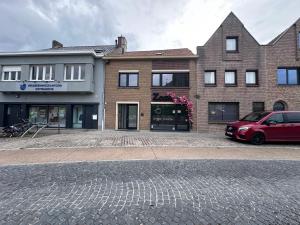 a red car parked in front of a brick building at Zaza Suites in Middelkerke
