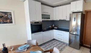 a kitchen with white cabinets and a stainless steel refrigerator at Ruža Vacation House in Međugorje