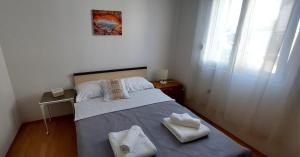 a small bedroom with a bed with two towels on it at Ruža Vacation House in Međugorje