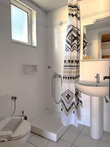 a white bathroom with a sink and a toilet at Vaso Alykanas Studios in Alikanas