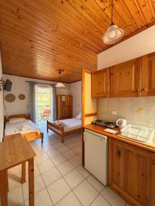 a kitchen with wooden ceilings and a room with a bed at Vaso Alykanas Studios in Alikanas